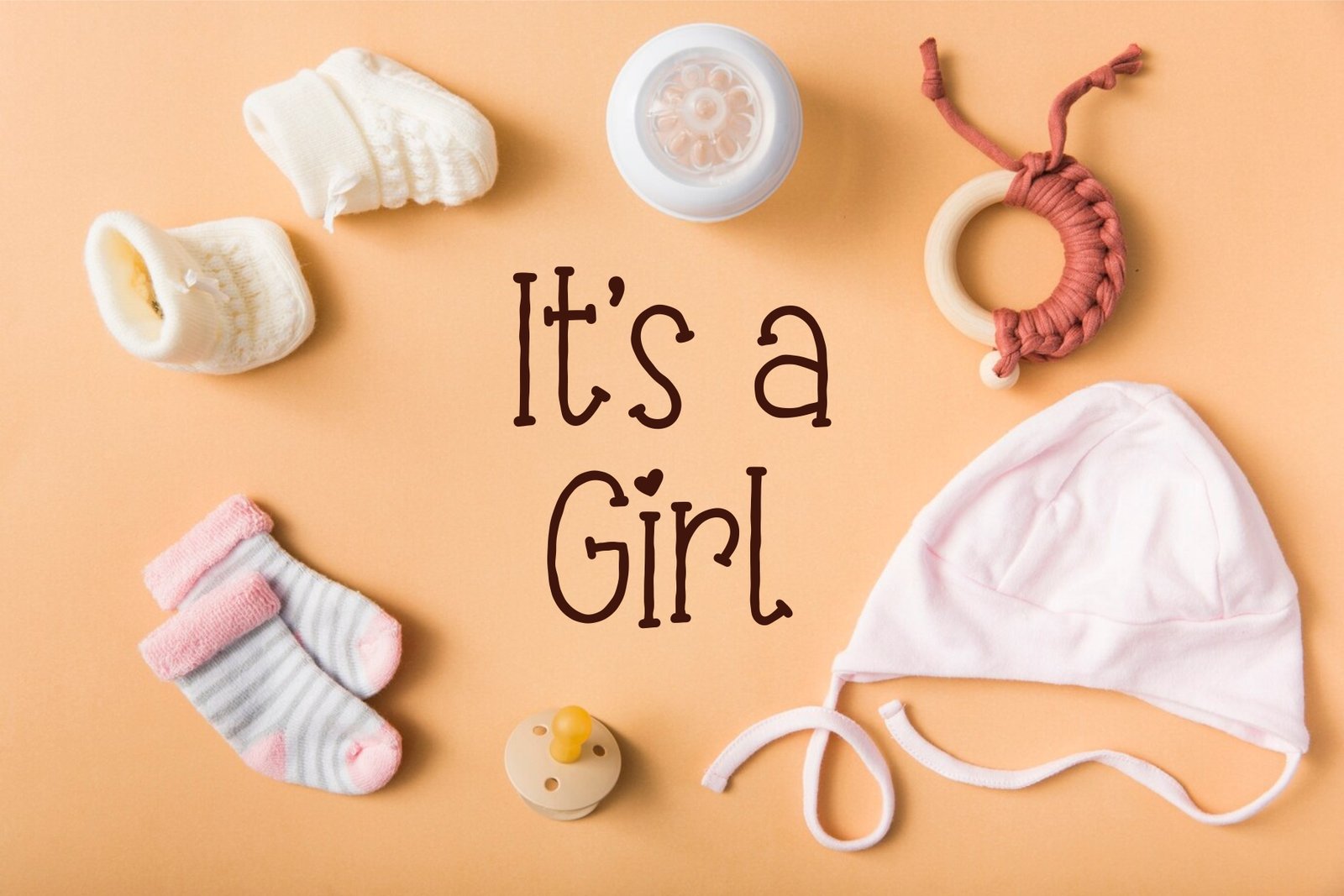 The Elabora font used in a baby-themed graphic saying "It's a Girl" surrounded by baby items like socks, a pacifier, and a hat.