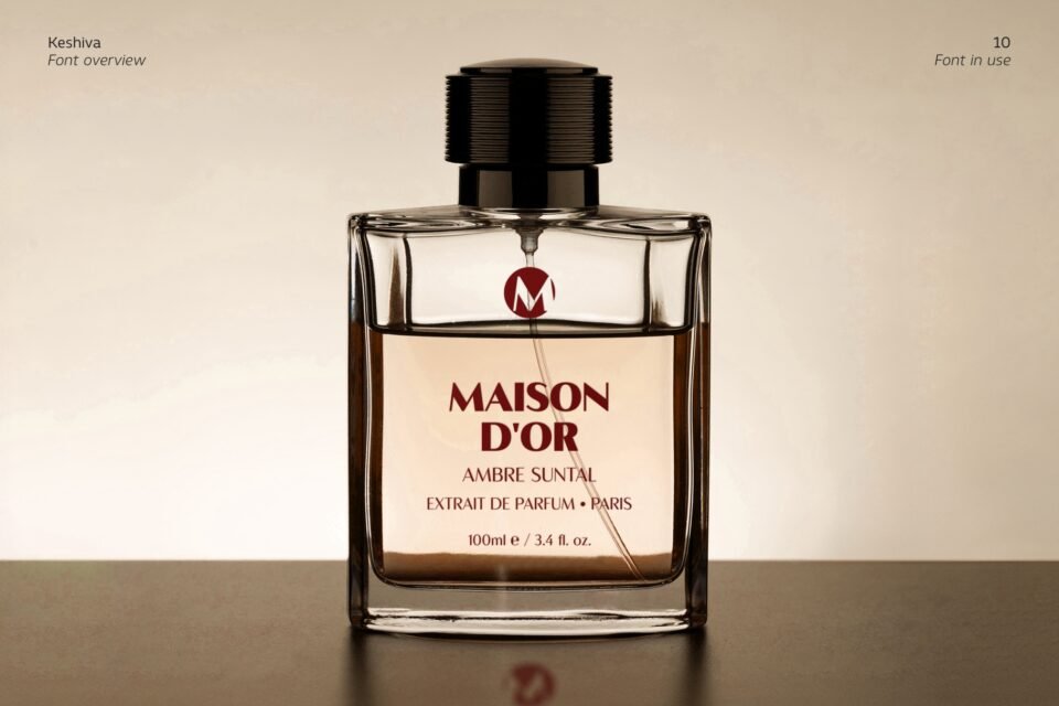 Elegant clear glass perfume bottle with liquid inside titled "MAISON D'OR AMBRE SUNTAL Extrait de Parfum Paris" utilizing Keshiva typography on a neutral background.